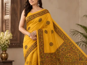 Mustard yellow cotton saree featuring traditional Mithila painting artwork with bird motifs, floral borders, and detailed Madhubani pallu design.